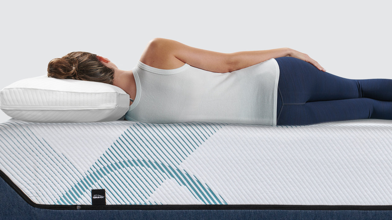 A person lying comfortably on their Temper-pedic mattress